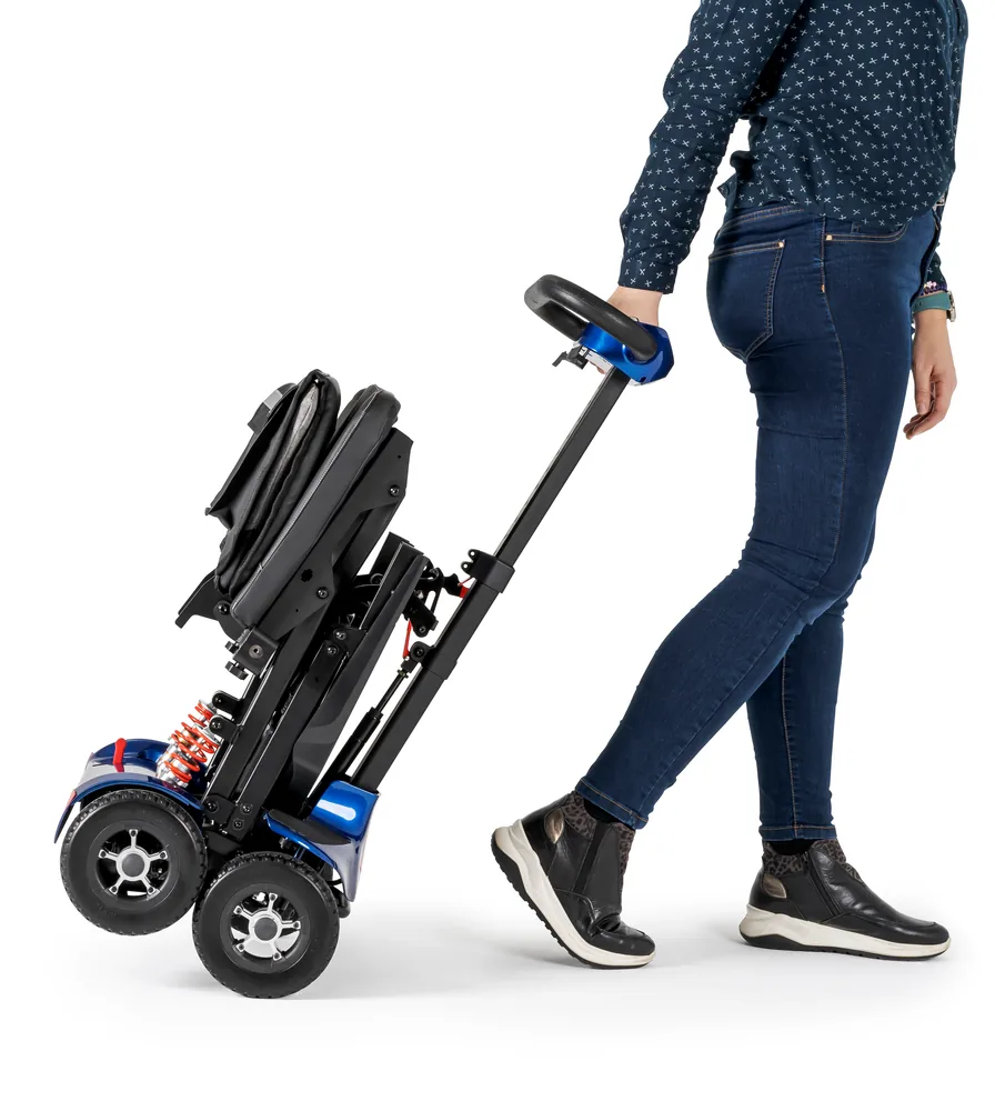Mujer tirando del scooter I-Transformer Lite plegado como un trolley