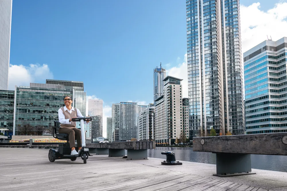 Scooter eléctrico WHILL Model R de 3 ruedas en un entorno urbano